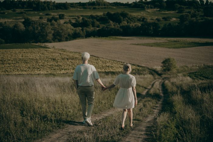 Two people walking a countryside lane at golden hour — Anastasiia Chaikovska on Pexels