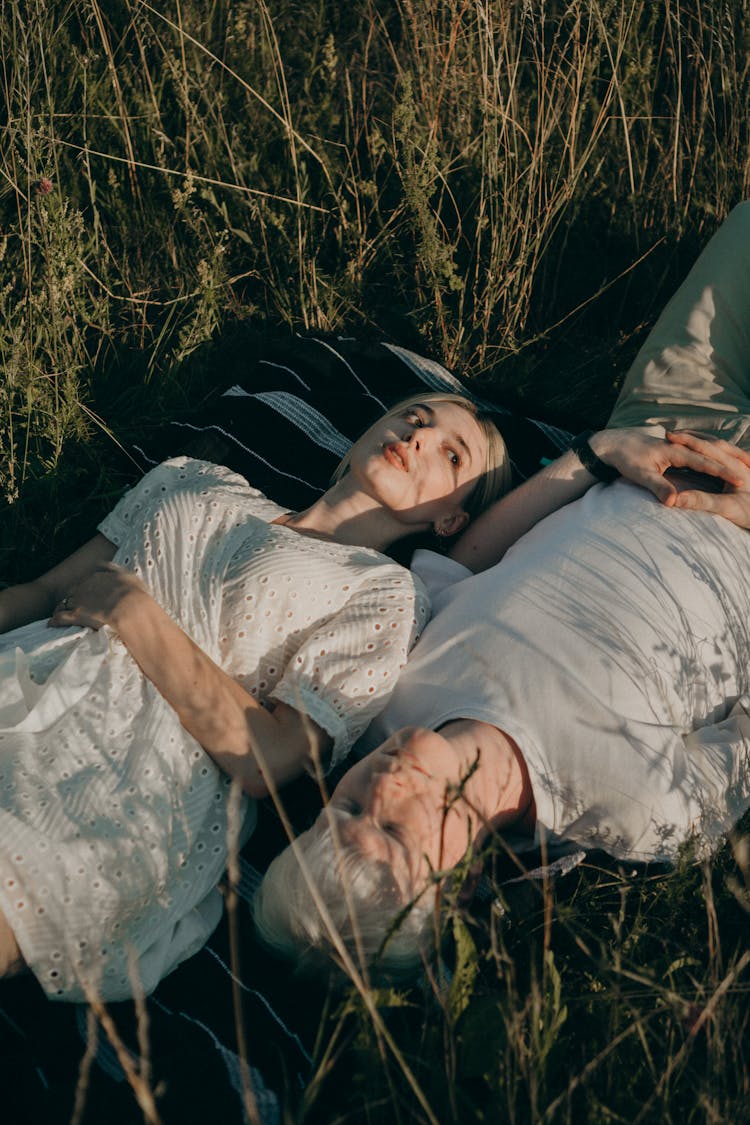 Couple Lying In Grass In Field