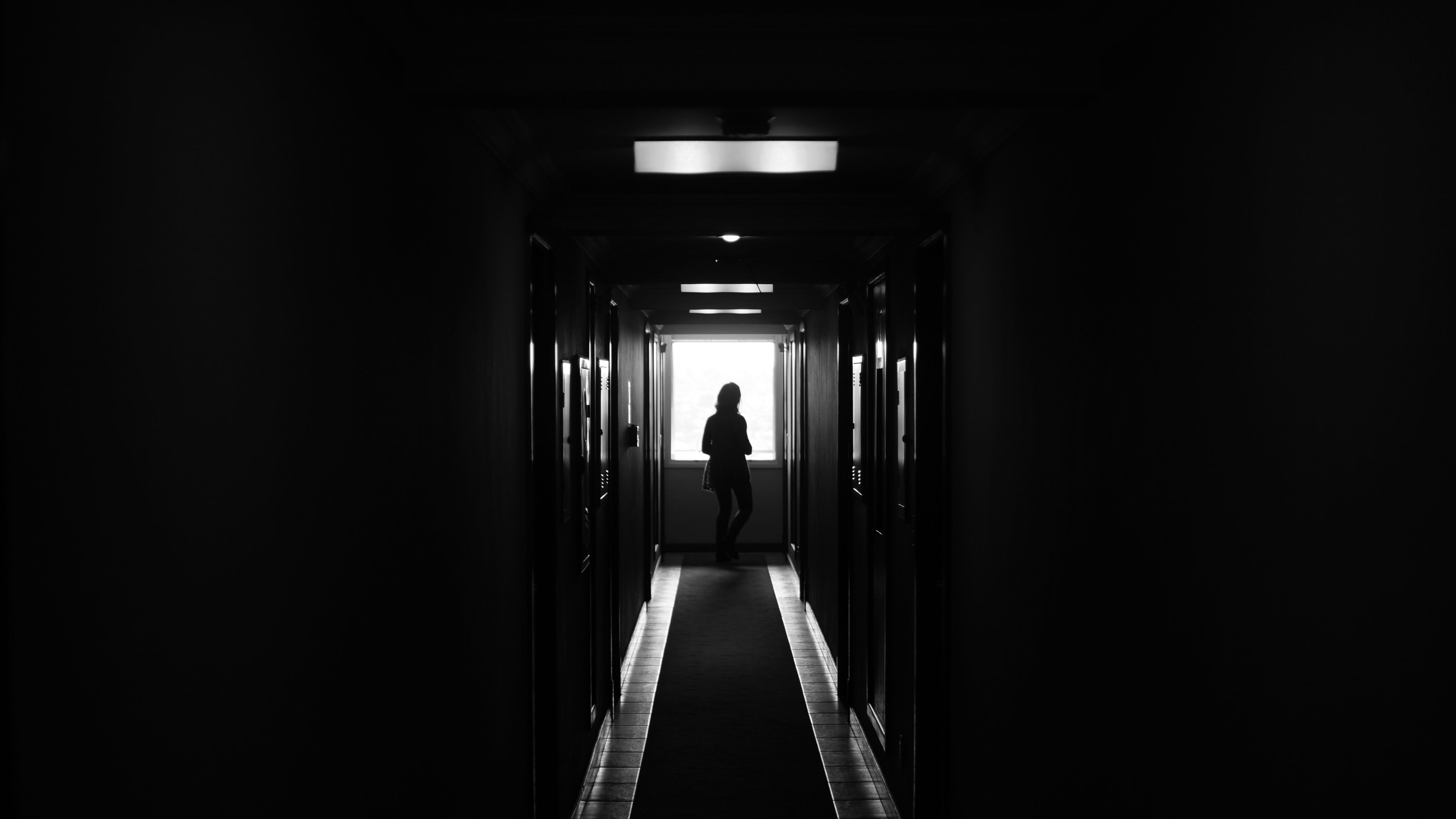 Person Standing On Dark Hallway Free Stock Photo person-standing-on-dark-hallway-free-stock-photo