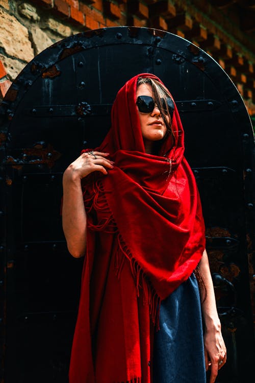 Woman in Red Headscarf Standing Beside a Doors