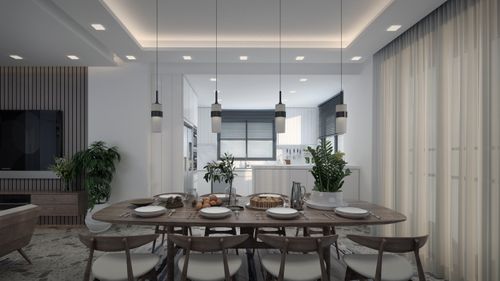 Free A modern, stylish dining room with an elegant dining table and contemporary kitchen in the background. Stock Photo