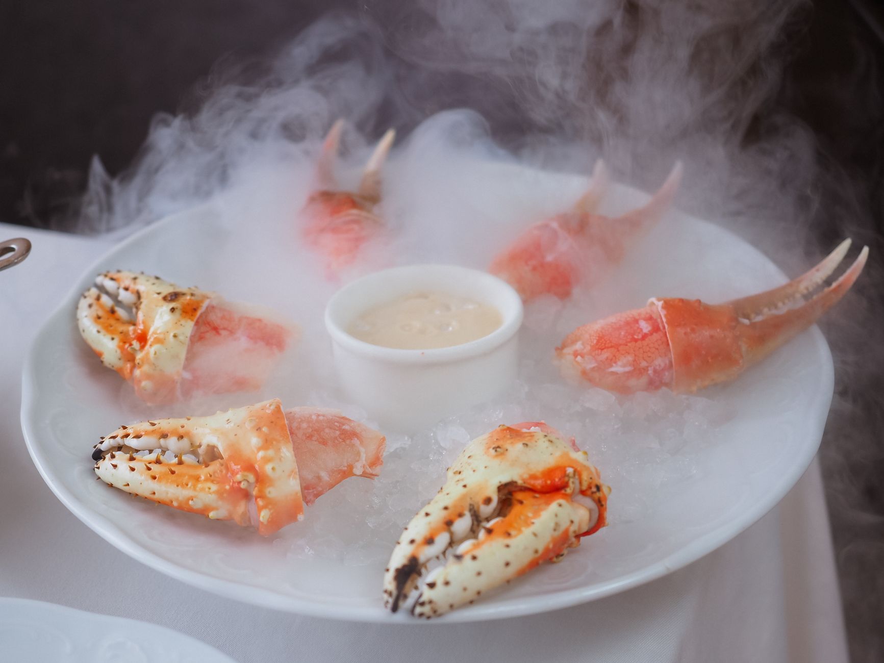 Steaming crab legs with fresh lemon and herbs in a pot