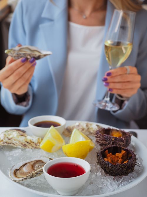 Free Delicious seafood platter with oysters, sea urchins, and wine. Perfect for a lavish dining experience. Stock Photo