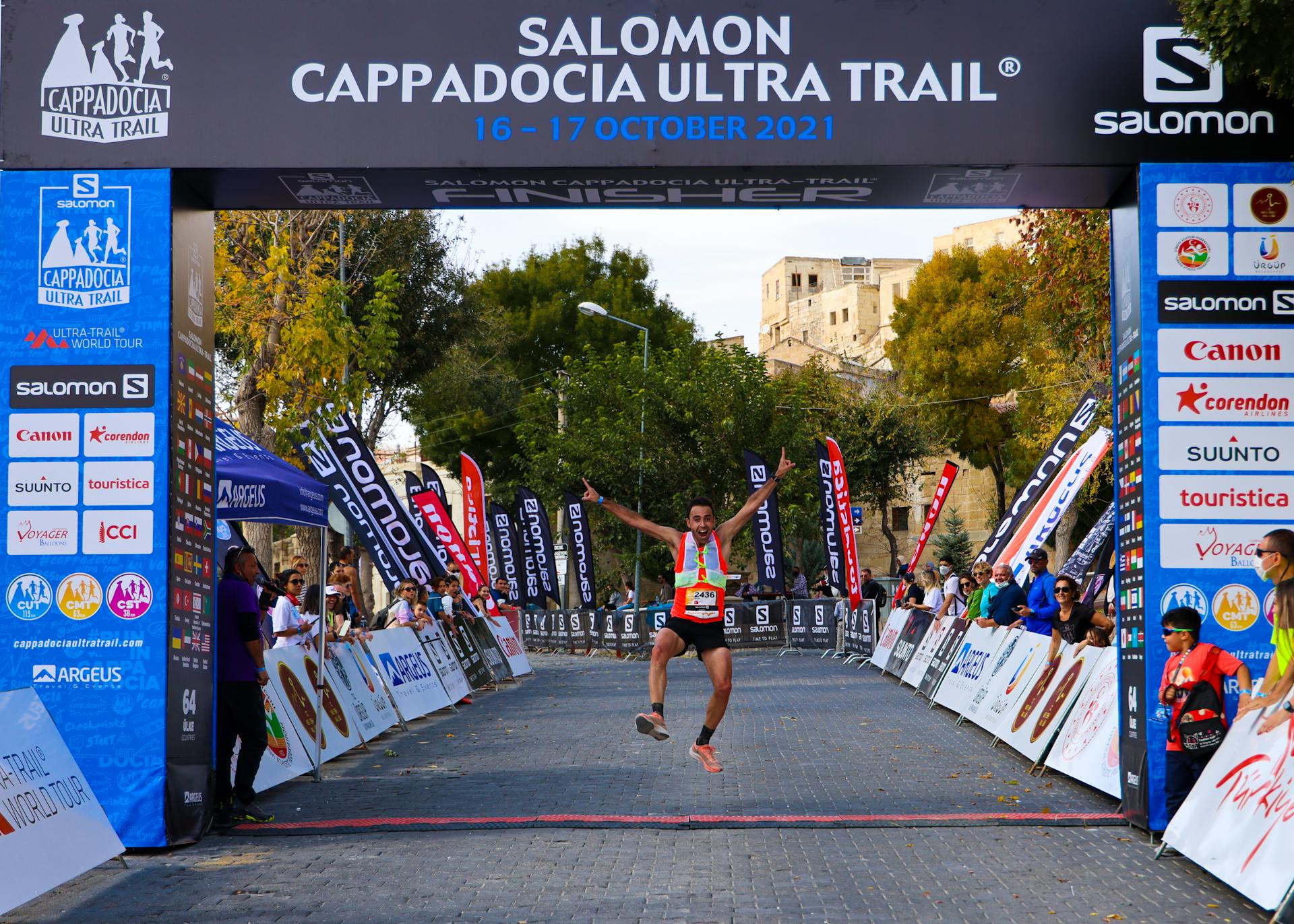 Excited athlete finishes the Cappadocia Ultra Trail with a triumphant jump.
