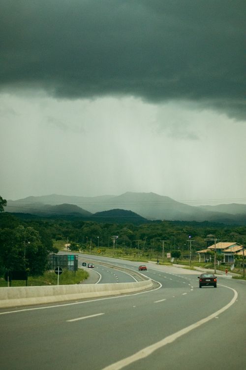 Free A winding rural highway under a dramatic stormy sky in Goiás, Brazil, showcasing nature's power. Stock Photo