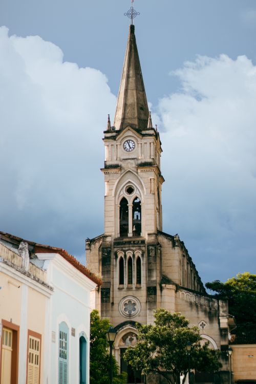 Free Gothic church steeple in historic Goiás, Brazil, showcasing urban architecture with a dramatic sky. Stock Photo