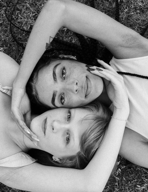Top view black and white portrait of two women embracing, symbolizing unity and diversity.