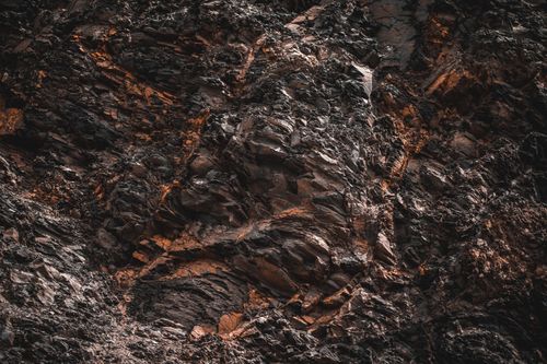 Free Close-up of jagged, textured natural rock formation with dramatic lighting and earthy tones. Stock Photo