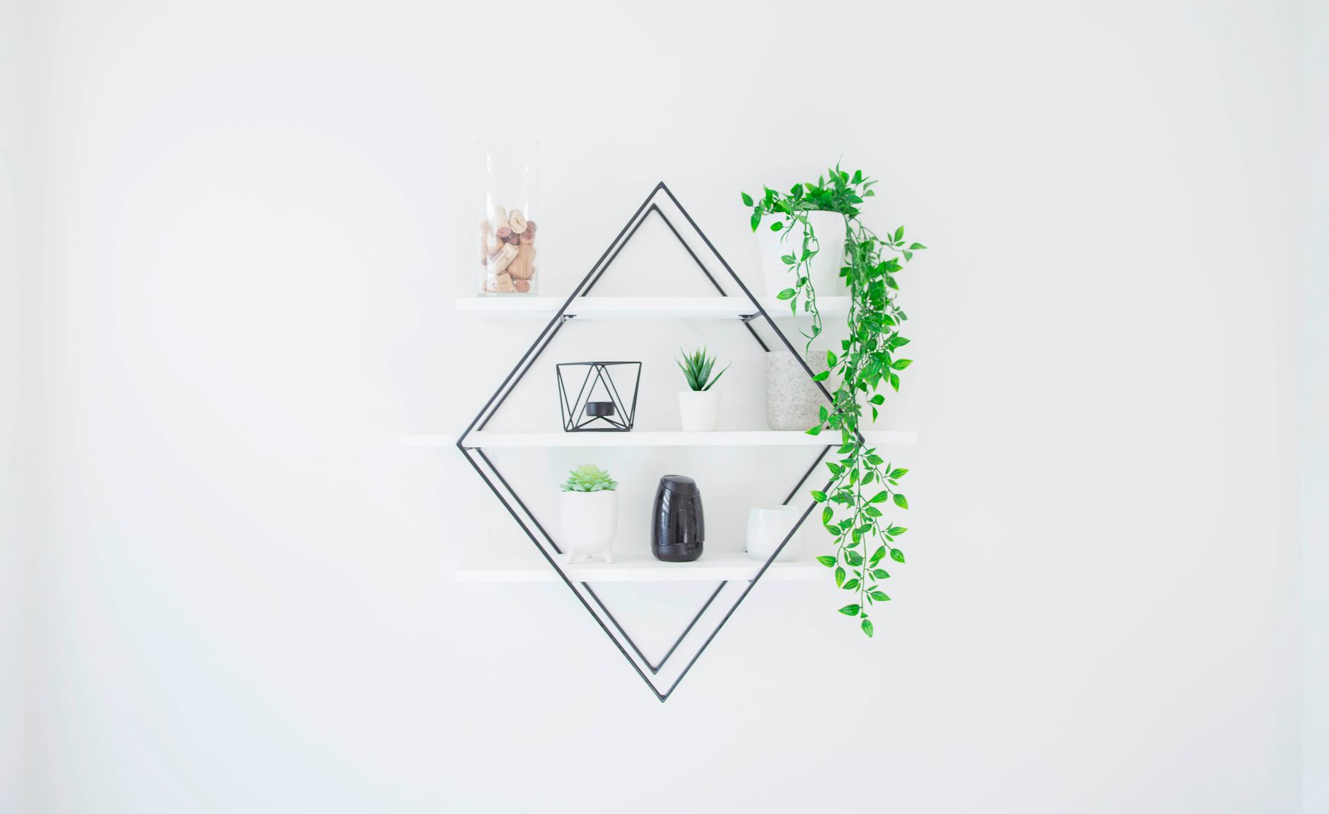 aesthetic living room upgrade with amazon finds A sleek white wall shelf with green plants and decor for a minimalist home design.