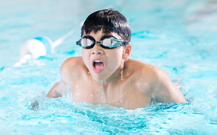 A Boy Swimming In The Pool