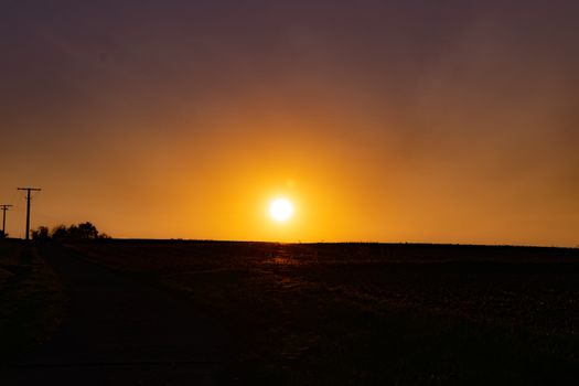 Beautiful sunset over a rural landscape, showcasing the vibrant golden hour glow.