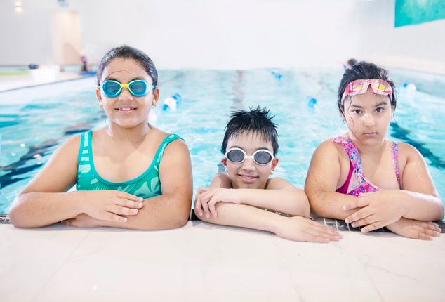 Kleine kinderen in zwemles met trainer