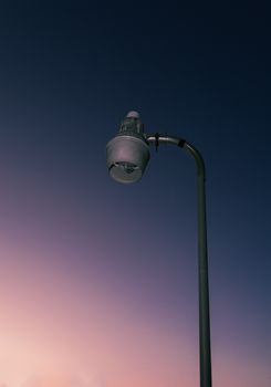 A solitary street lamp stands against a beautifully colored twilight sky.