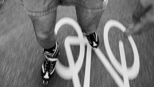 A Person Riding Rollerblades on Pavement