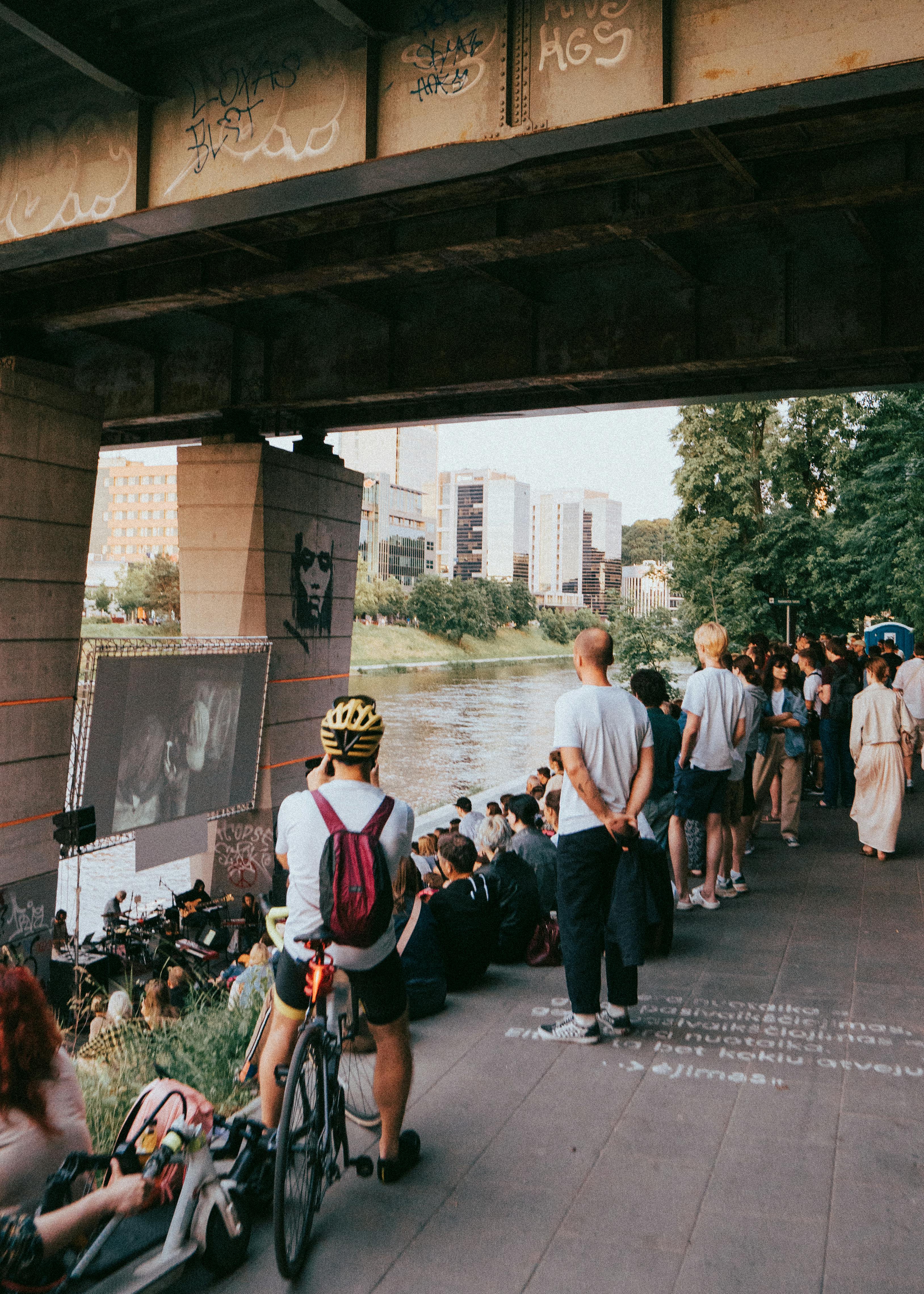 Free A lively crowd enjoys an outdoor movie screening under a bridge in Vilnius, Lithuania. Stock Photo