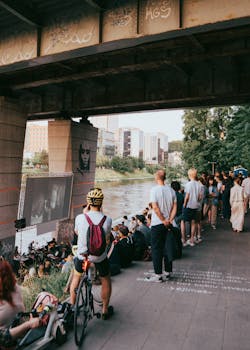 A lively crowd enjoys an outdoor movie screening under a bridge in Vilnius, Lithuania.