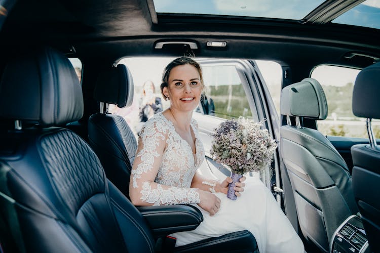 Bride Sitting In The Back Of A Car 