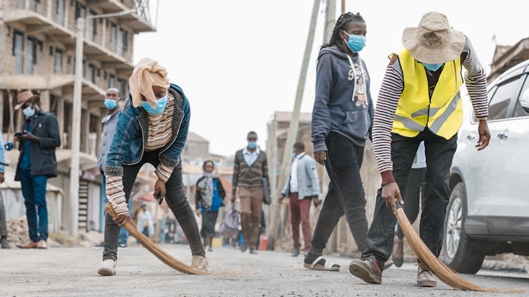 People Sweeping The Street