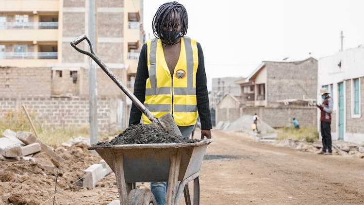 Woman Working With Wagon At Construction Site