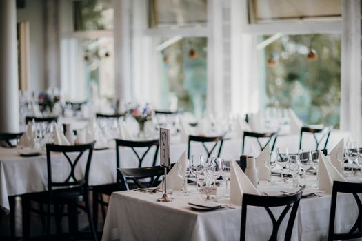 Beautifully set dining tables, perfect for a wedding reception or formal dinner event, captured indoors.