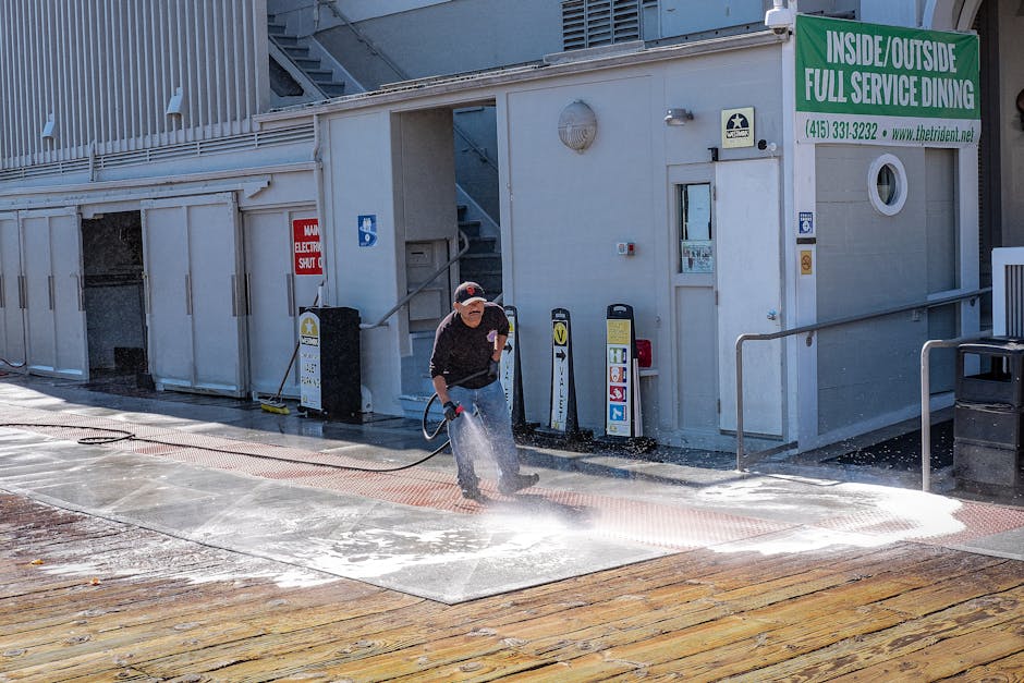 Man Cleaning Sidewalk with Garden Hose