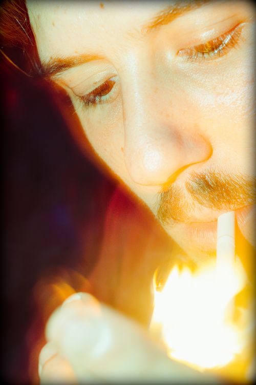 Free A close-up shot of a person lighting a cigarette, showing warm and vibrant tones. Stock Photo