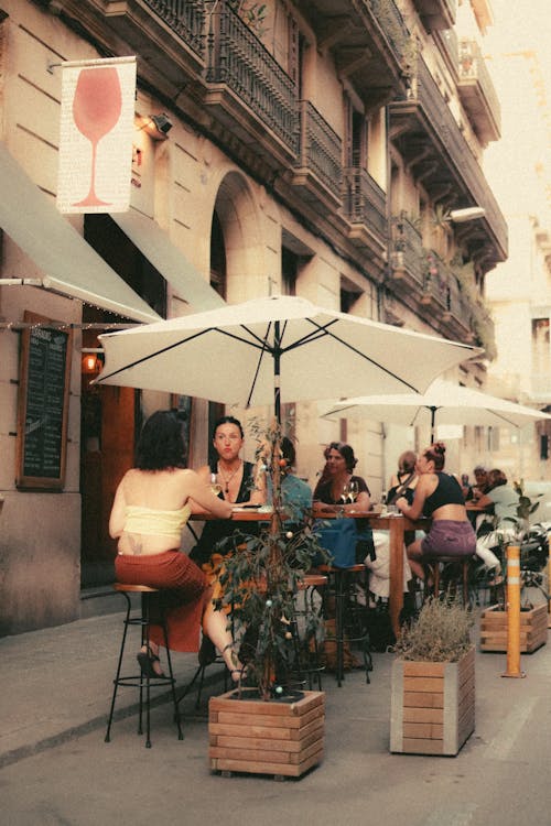 Women Sitting on Tables in Outdoor Cafe Terrace