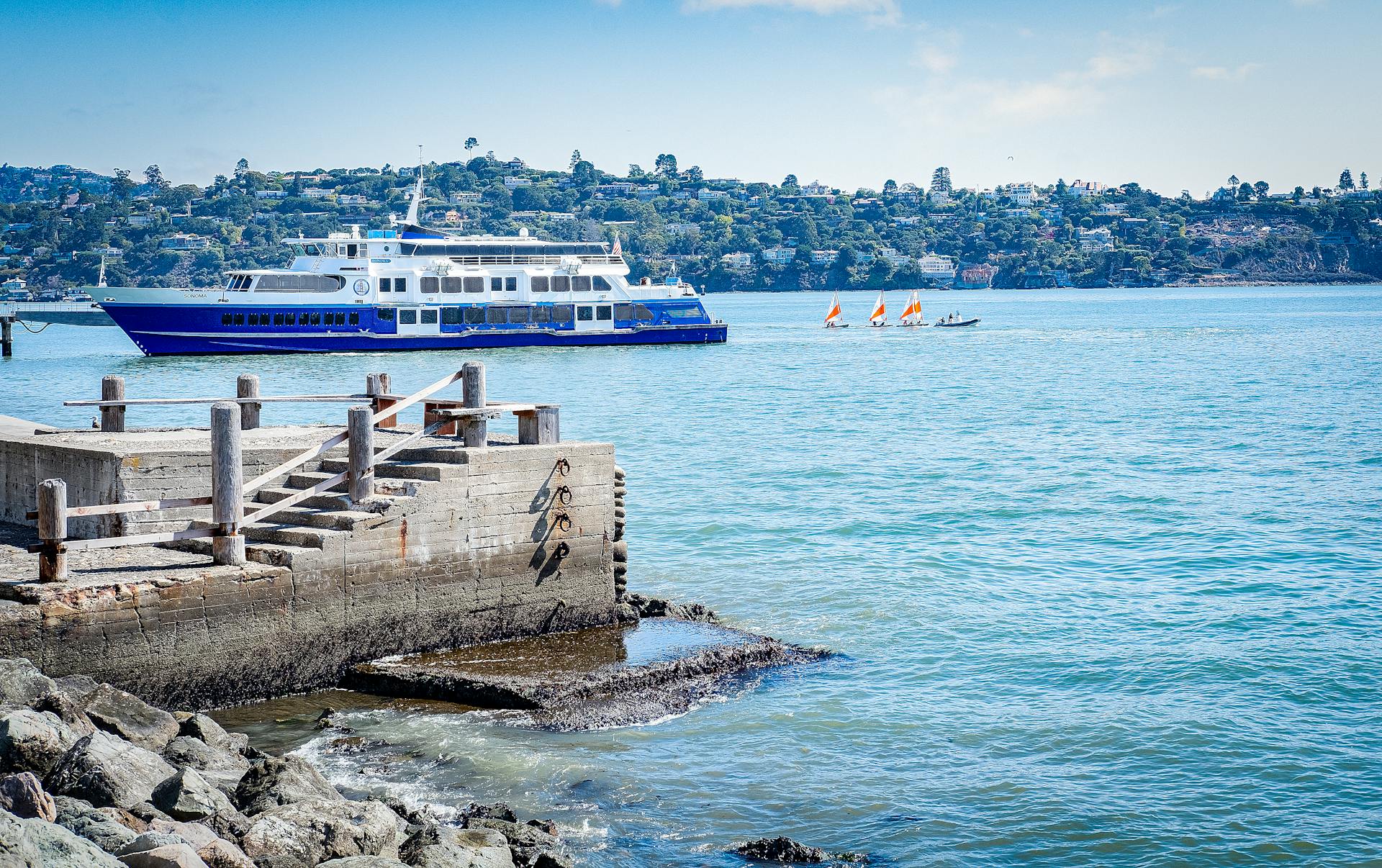 A colorful boat cruising near the harbor with a picturesque island backdrop.