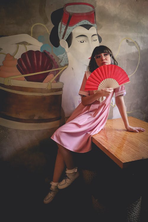 Woman in Pink Dress Holding a Hand Fan