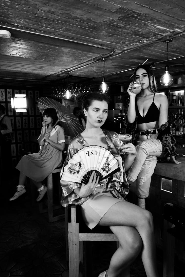 Grayscale Photo Of Women Drinking At The Bar