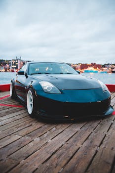 Stylish Nissan 350Z sports car parked on a wooden deck at a vibrant waterfront location.