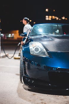 Close-up of a blue Nissan 350Z at a gas station, capturing the sleek design at night.