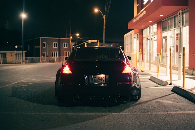 Back View Of A Car Stopping On A Car Park At Night