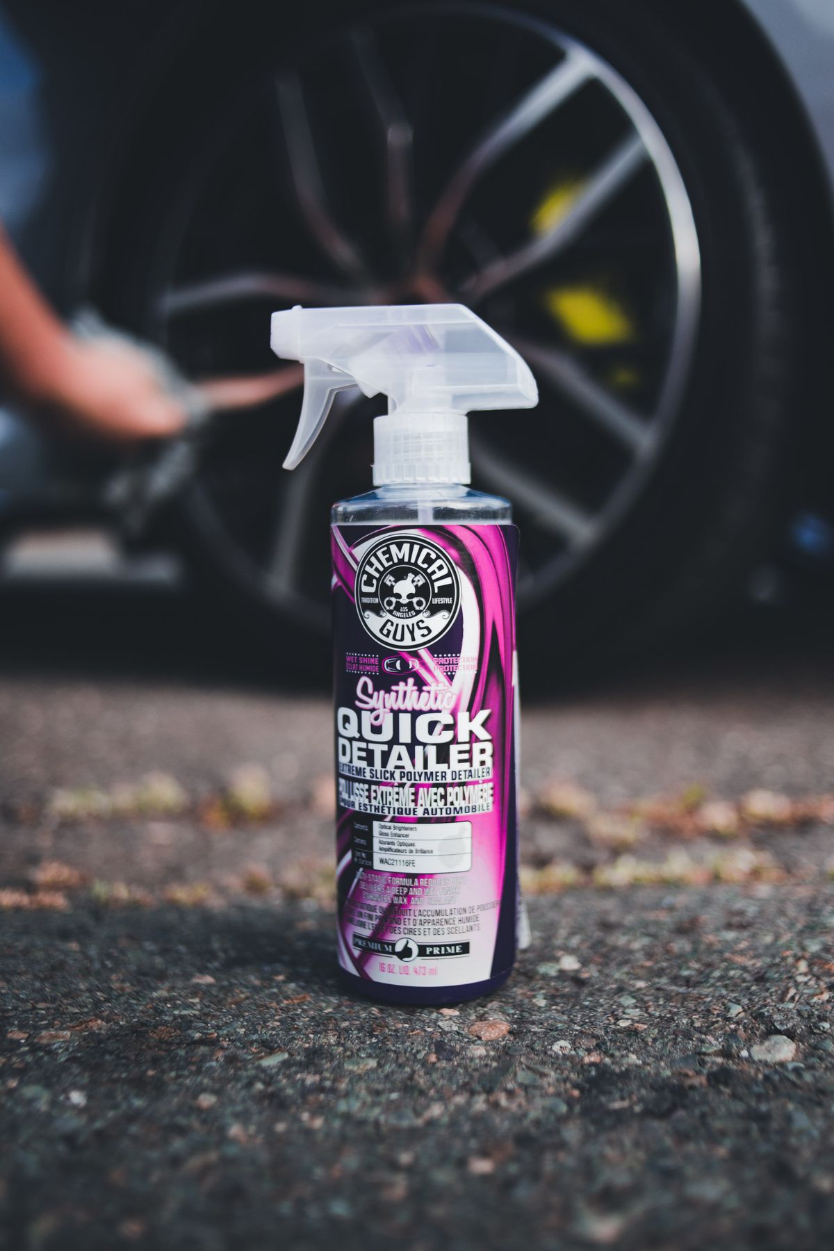 Detailing spray bottle beside a car during glass and surface treatment