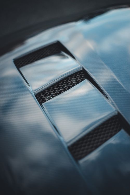 Free Detailed close-up of a car hood vent with sleek silver finish, showcasing modern automotive design. Stock Photo