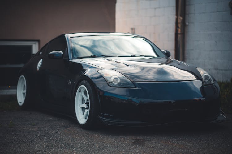 Black Sports Car Parked Beside White And Brown Building