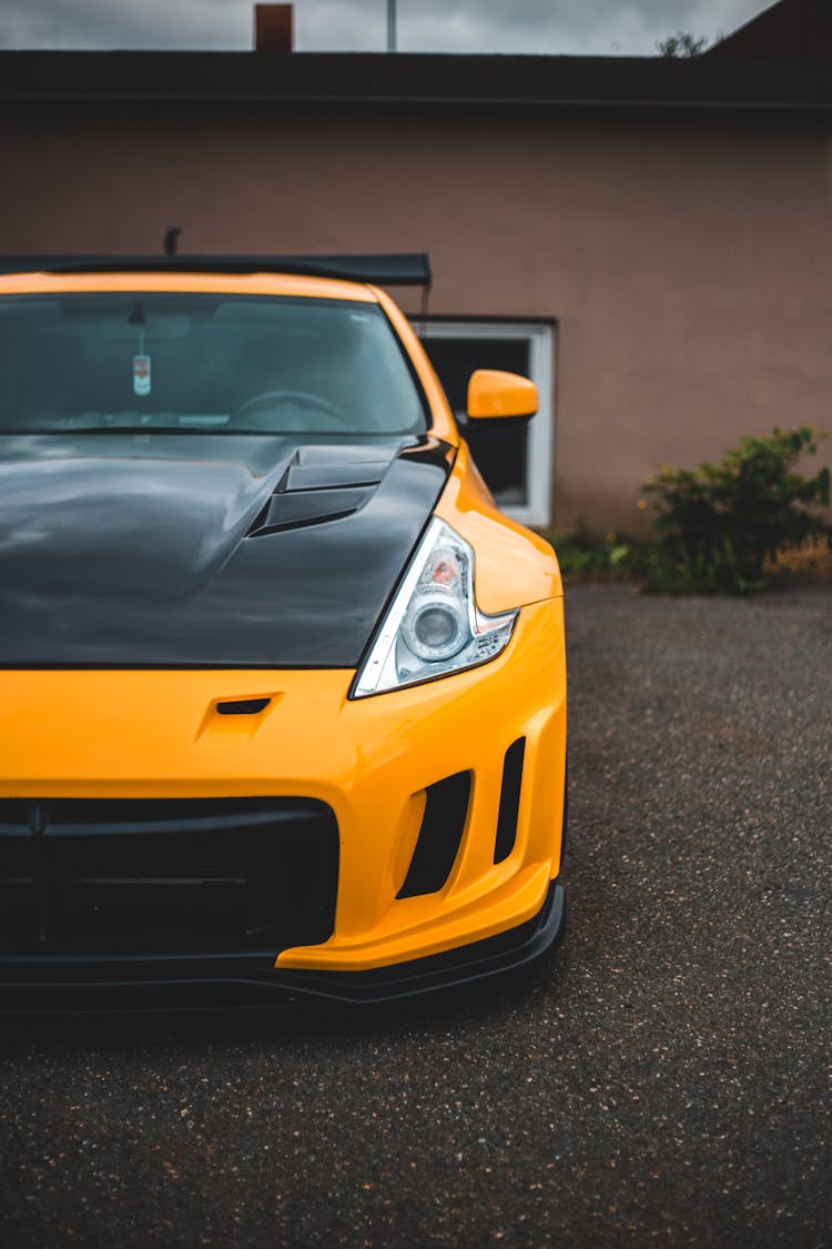 Yellow Nissan Car With Black Hood In The Parking Lot