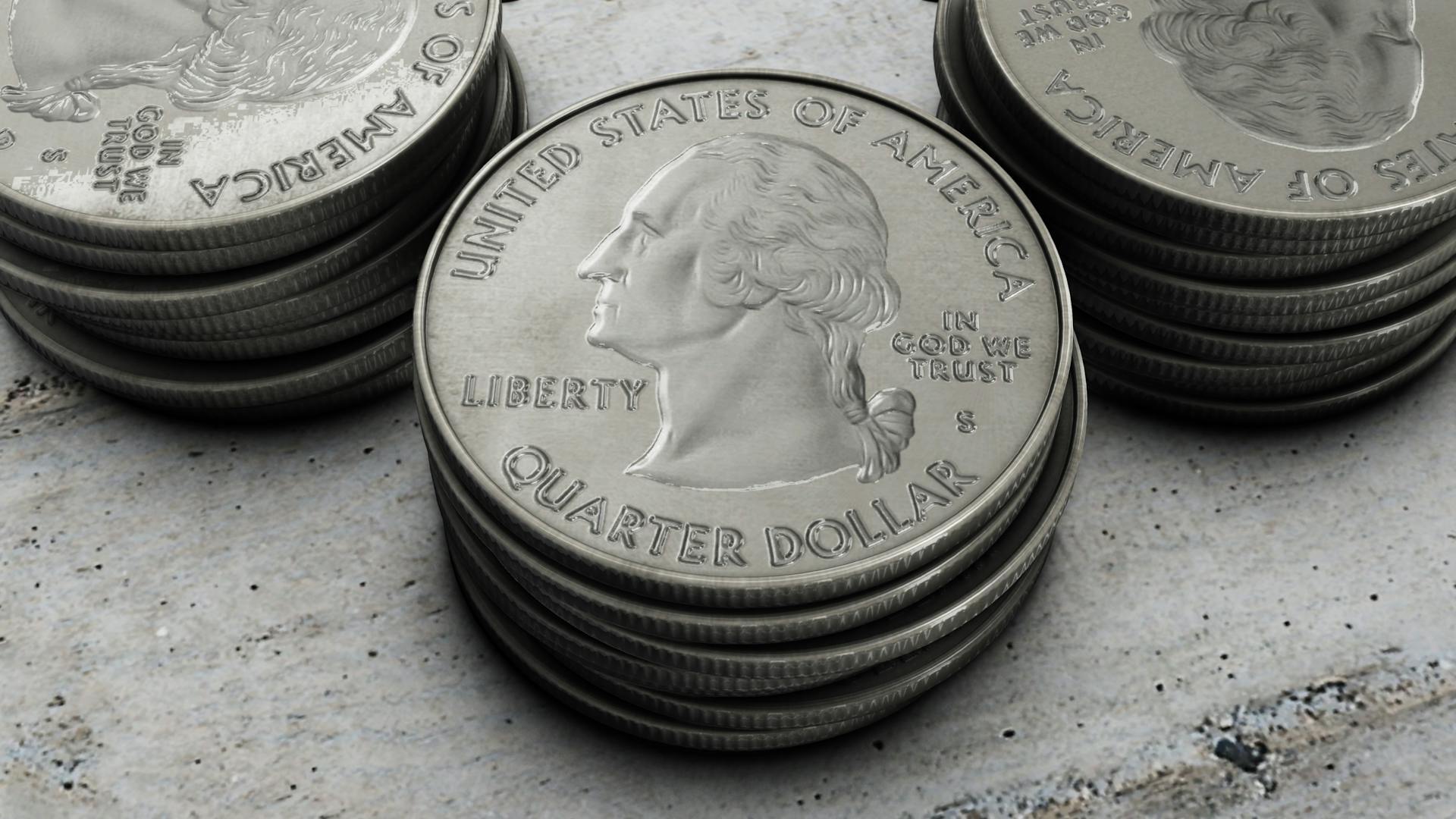 Detailed image of stacked silver US quarter coins showing engraved design.