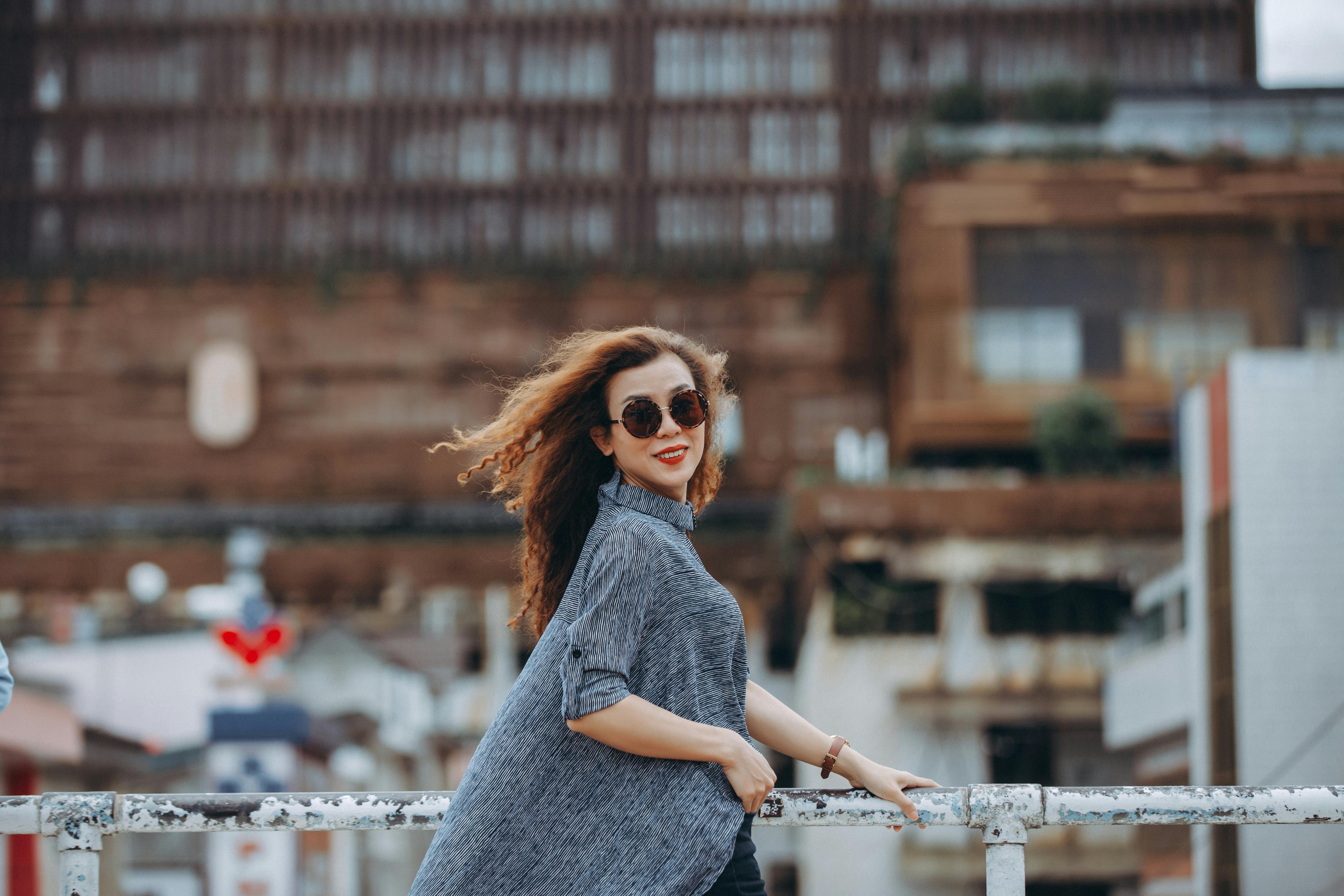 portrait of a brunette woman wearing sunglasses in city