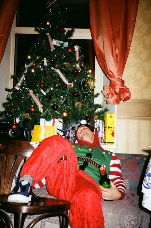 Man Lying Beside Green Christmas Tree