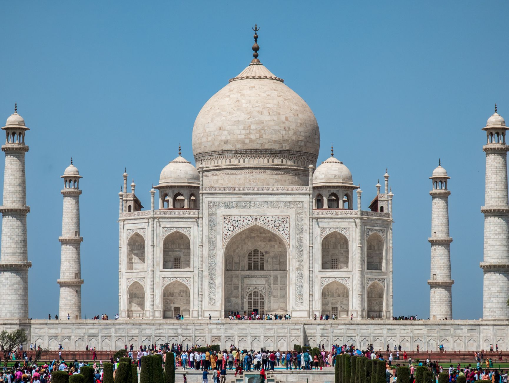 A captivating view of the Taj Mahal under a clear blue sky, showcasing its iconic architecture.
