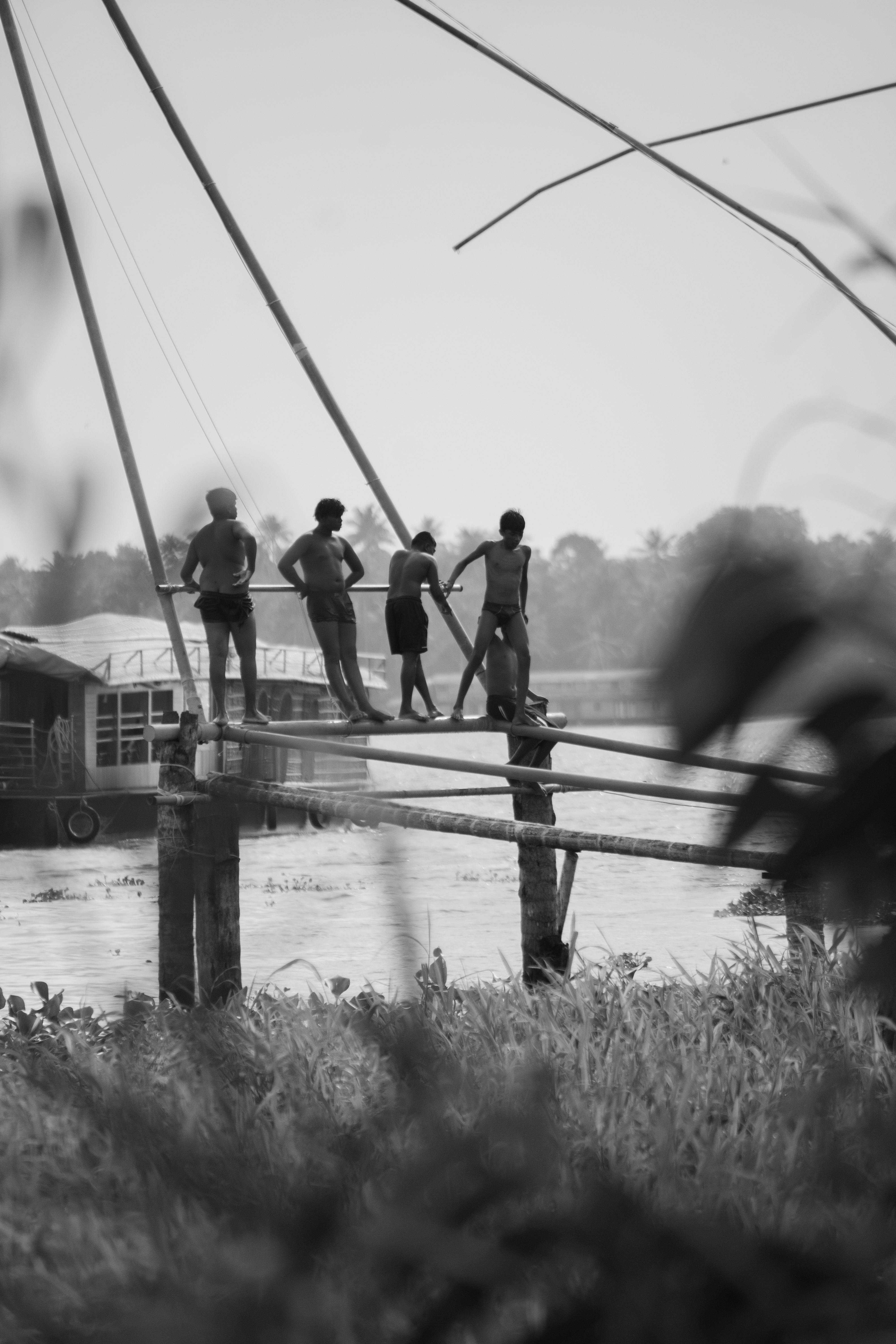 Black and white image of boys gathered on a pier in India.
