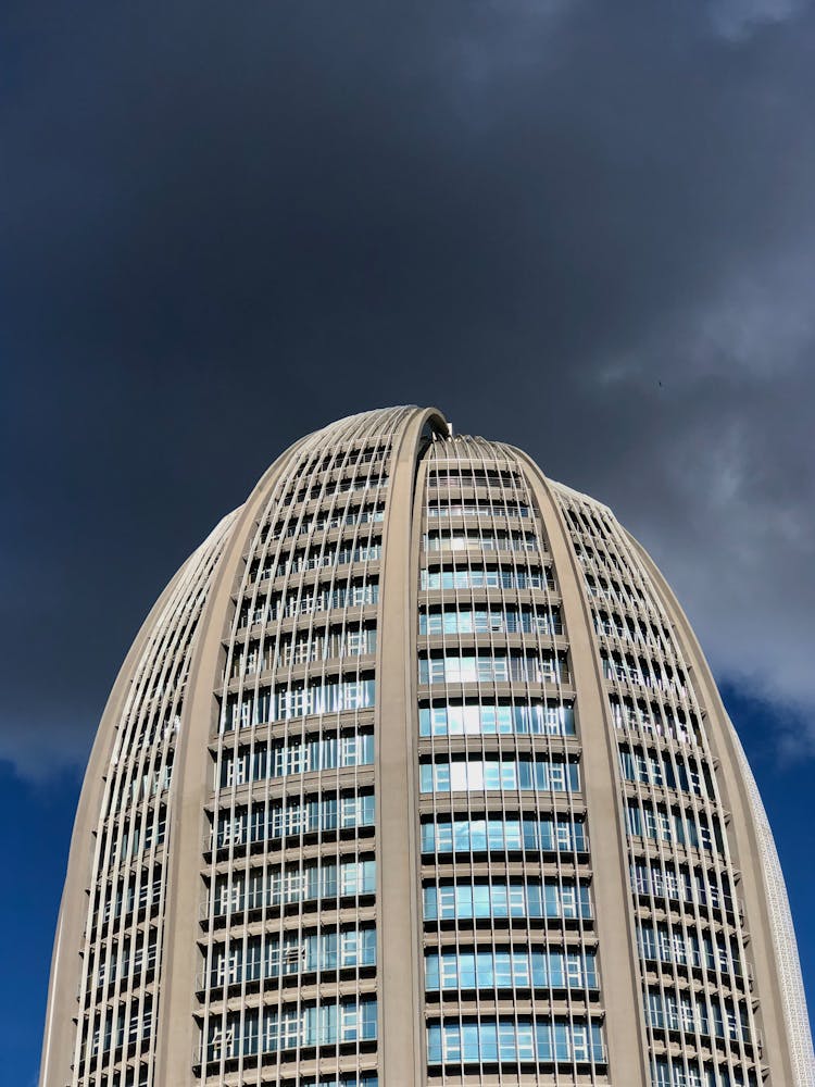 Oval Modern Building Against Dark Cloud