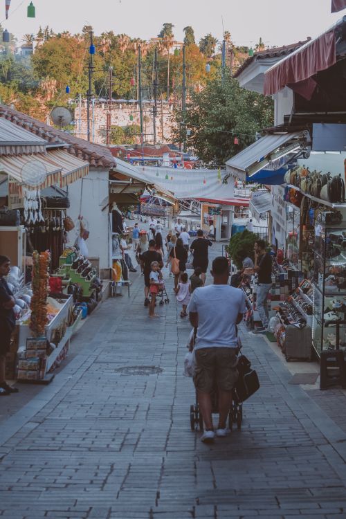 Free People walking through a vibrant street market lined with colorful stalls and various goods. Stock Photo
