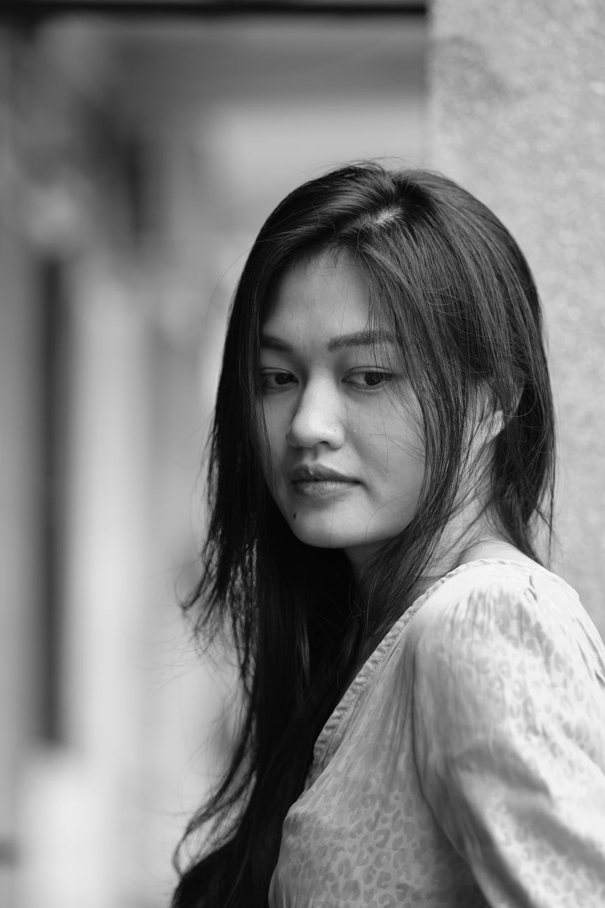 Stunning black and white portrait capturing a thoughtful young woman.