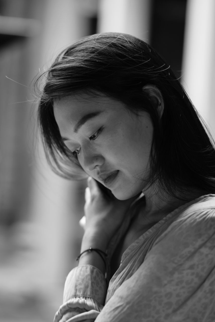 Elegant black and white portrait capturing a thoughtful young woman.