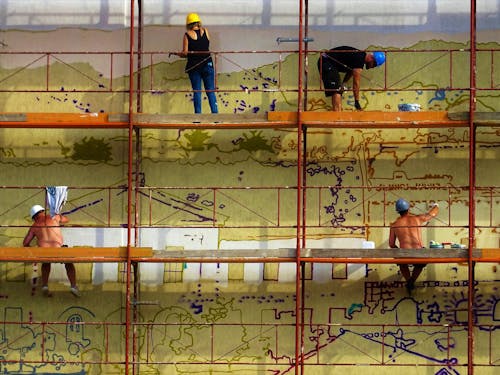Free Four People Painting Wall on Scaffolding Stock Photo
