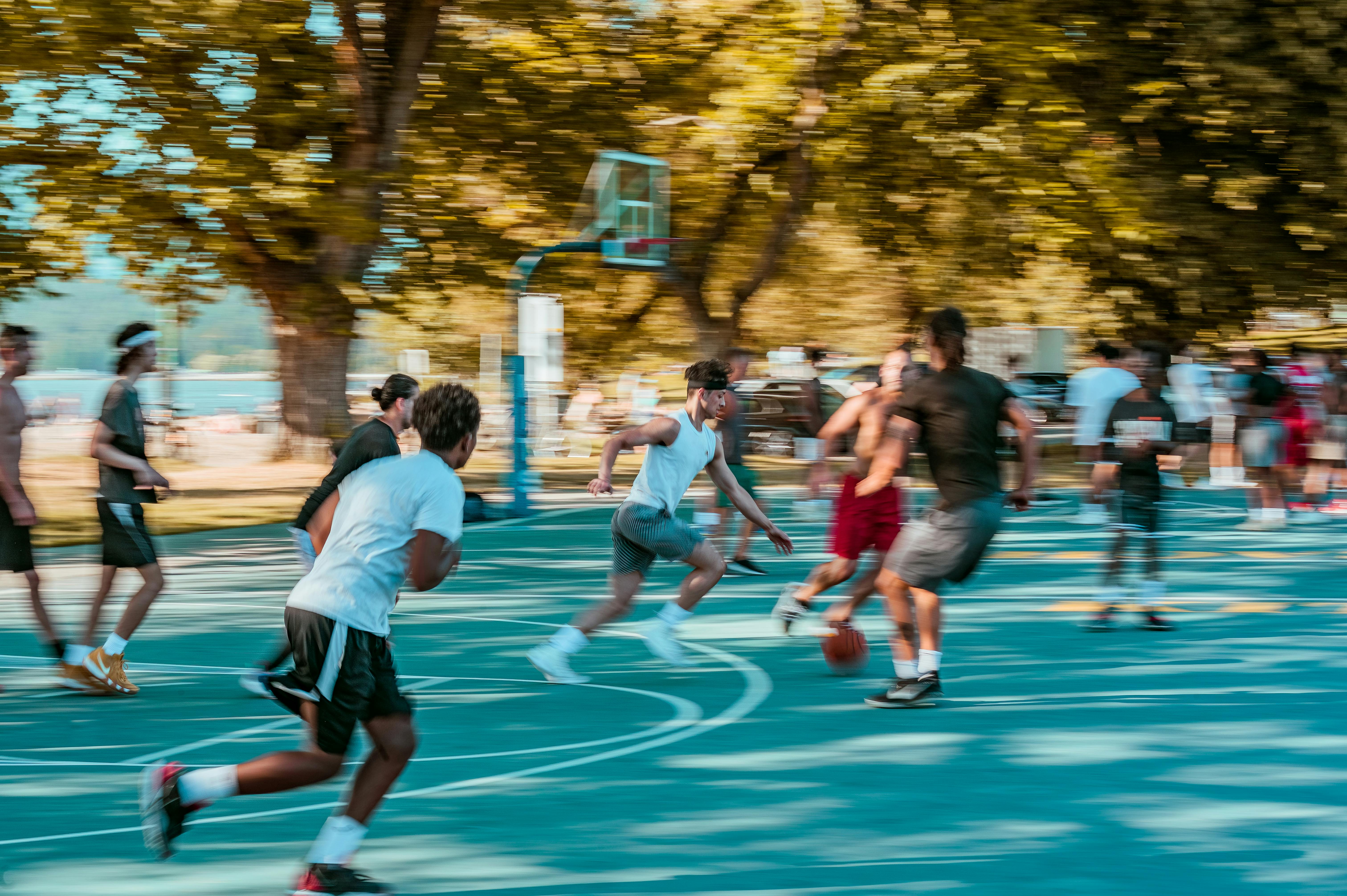 basketball players running inside court during sunset