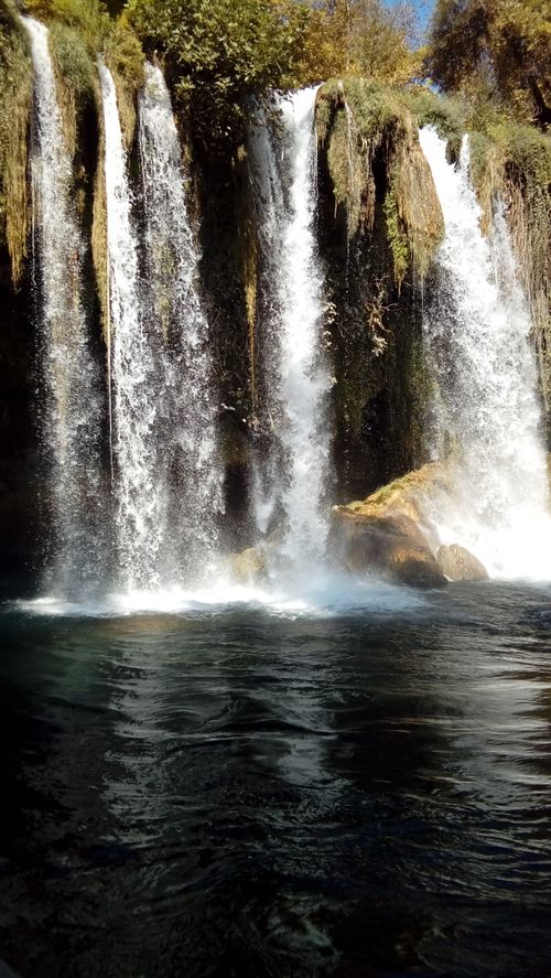 Free Tranquil view of a waterfall cascading over rocks in a picturesque natural setting. Stock Photo