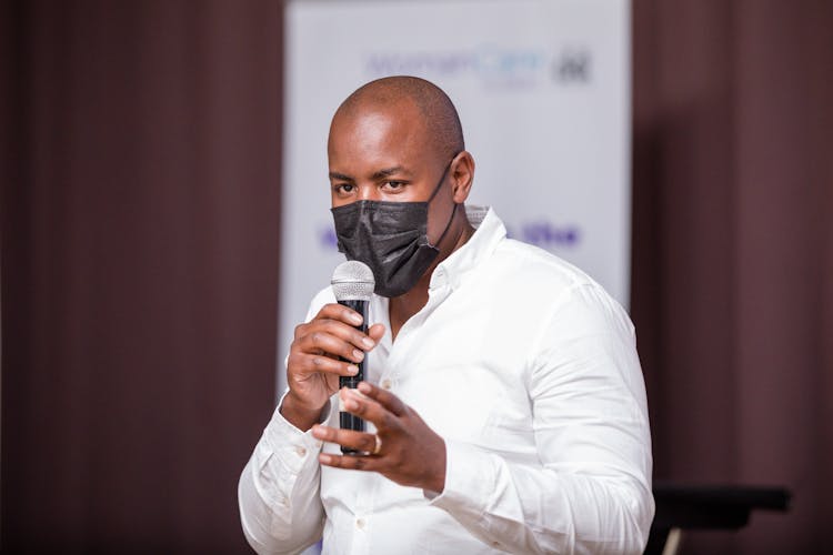 Man In Mask Speaking With Microphone